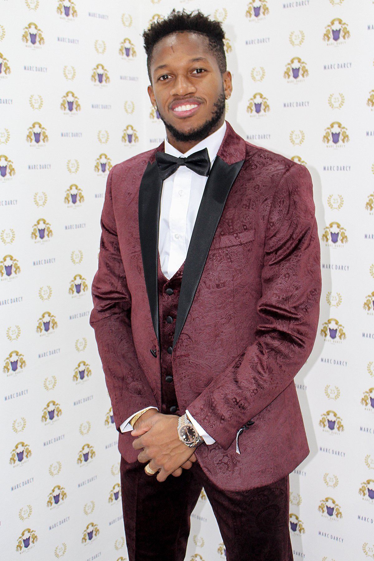 Fenerbahçe and Brazil midfielder Fred wears the Simon Wine velvet suit by Marc Darcy, smiling in front of a Marc Darcy step-and-repeat backdrop.