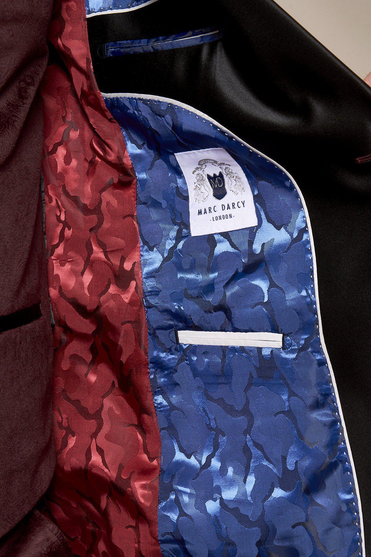 Close-up of the inside of Marc Darcy's Simon Wine Velvet Suit, as worn by Fenerbahçe and Brazil midfielder Fred, showing red and blue camouflage-patterned linings, a white Marc Darcy label, interior pocket, and black outer fabric.
