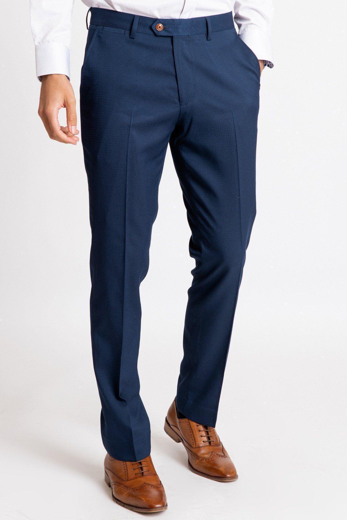 A person models the lower half of The Everton Collection | Vitalii Mykolenko In The MAX Royal Blue Suit pants by marcdarcy, paired with a white shirt and brown leather dress shoes, standing against a plain white background. Only the lower body is visible.