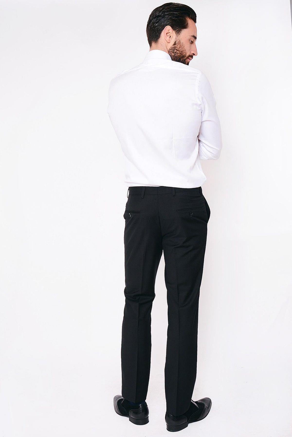 A man with dark hair, facing away from the camera, wears a white shirt and marcdarcy RAMBO Black Flat Fronted Trousers, ideal for smart-casual style, against a plain white background.
