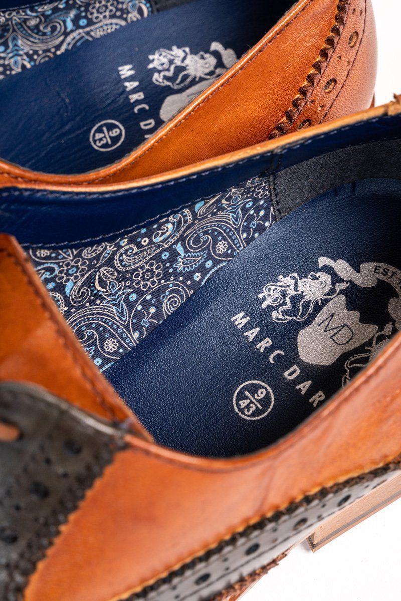 Close-up of Marc Darcy RILEY Tan Navy Leather Contrast Oxford Brogue shoes, featuring hand-stitched detailing, patterned blue insoles, a decorative crest logo, and visible shoe size.