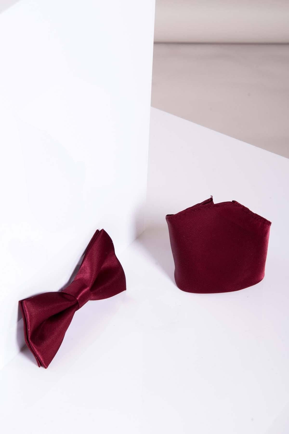 The Accessory STANLEY Satin Bow Tie and Pocket Square Set in Wine features a maroon satin bow tie and matching folded pocket square, elegantly displayed on a white surface—ideal for formal occasions.