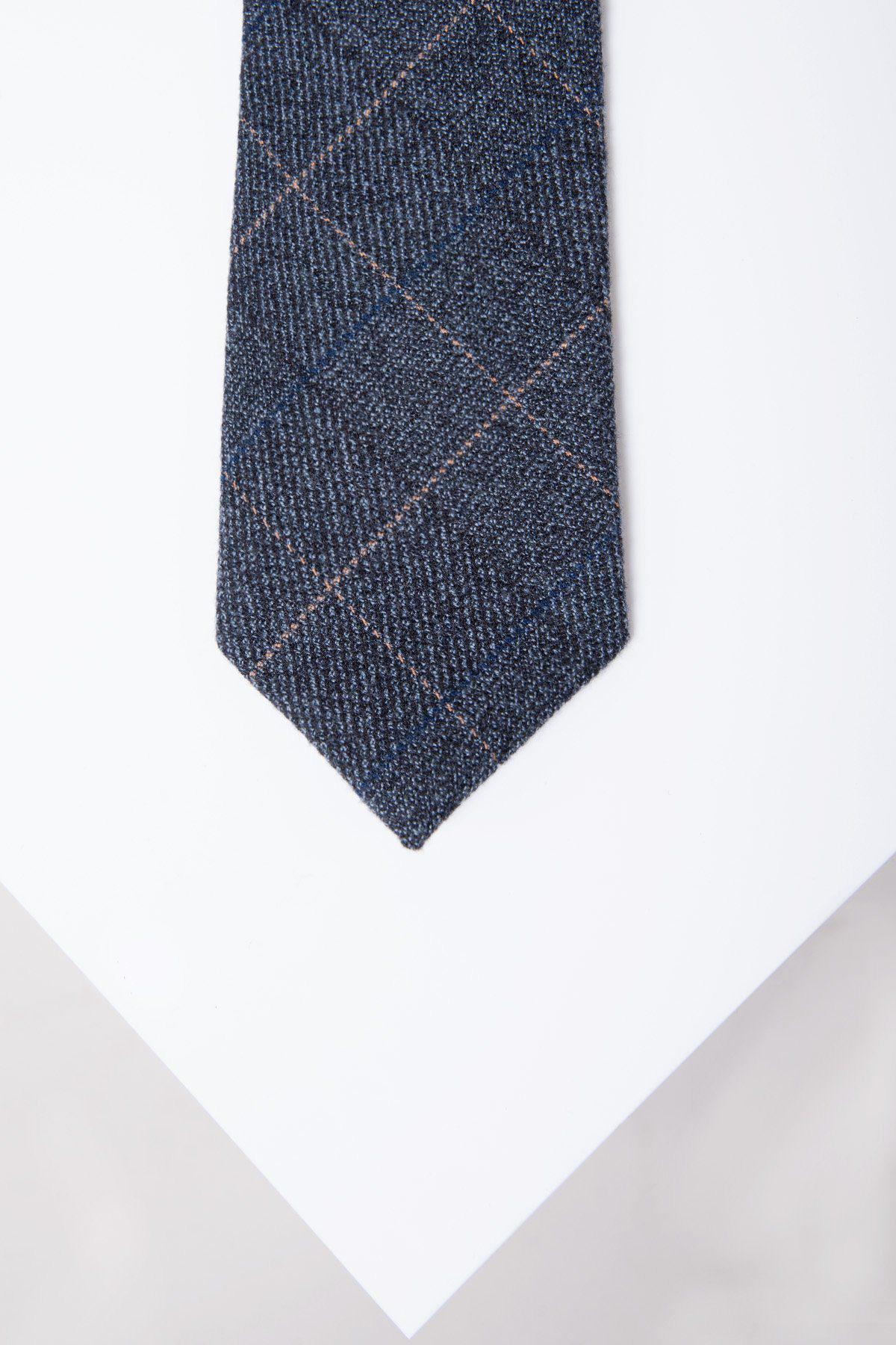 A close-up of the SCOTT - Blue Tweed Check Tie by Accessory, featuring dark blue plaid with subtle light lines, shown on a white angled surface.