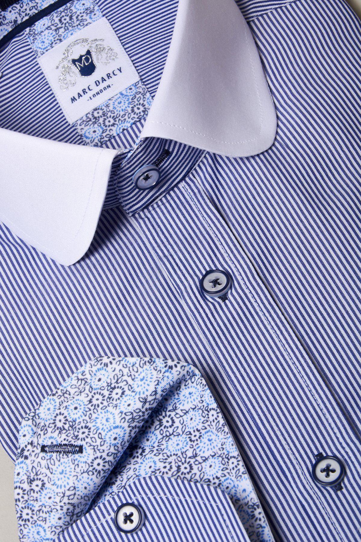 A close-up of the Marc Darcy SHELBY Navy Blue Stripe Penny Collar Shirt featuring blue and white stripes, a contrasting white penny collar, and floral inner cuffs—ideal for the style-conscious gent.