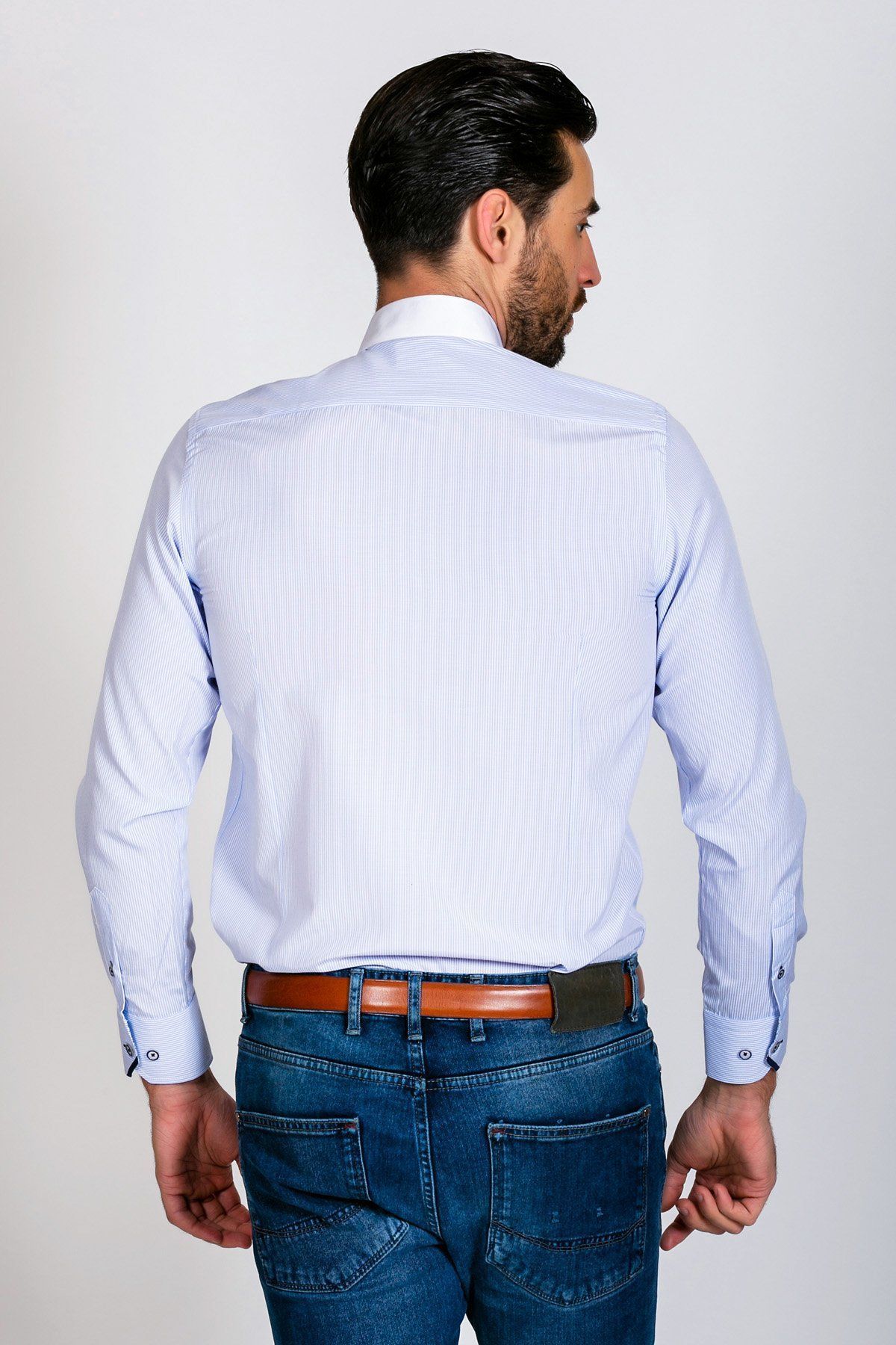 A man with short dark hair is shown from the back, wearing the Marc Darcy SHELBY - Sky Blue Stripe Penny Collar Shirt, blue jeans, and a brown belt against a plain light background.