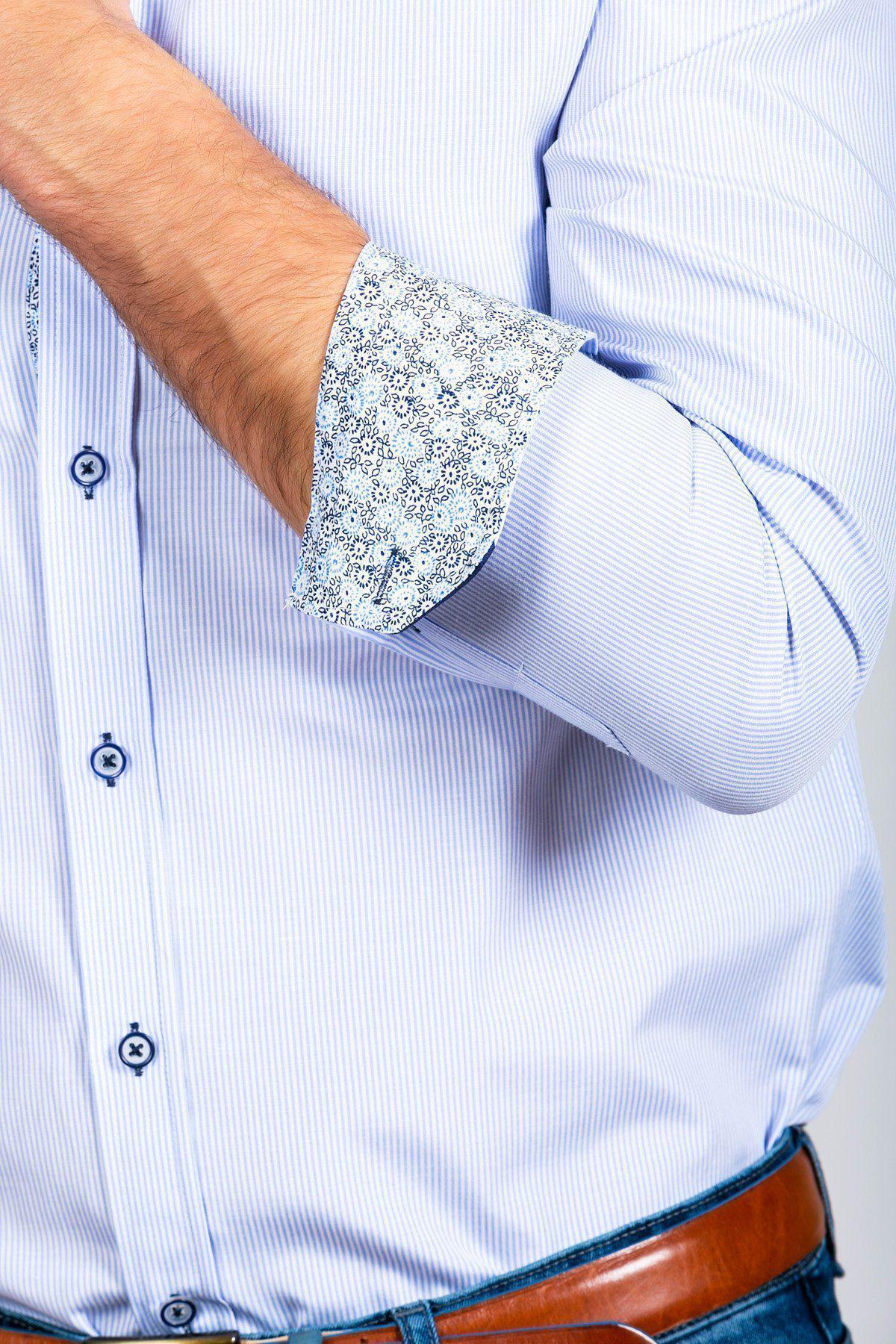 A person wears the Marc Darcy SHELBY Sky Blue Stripe Penny Collar Shirt, featuring floral-patterned cuffs partially rolled up, and blue jeans with a brown belt. Only the torso and one arm are visible. The shirt is crafted with high cotton content for comfort.