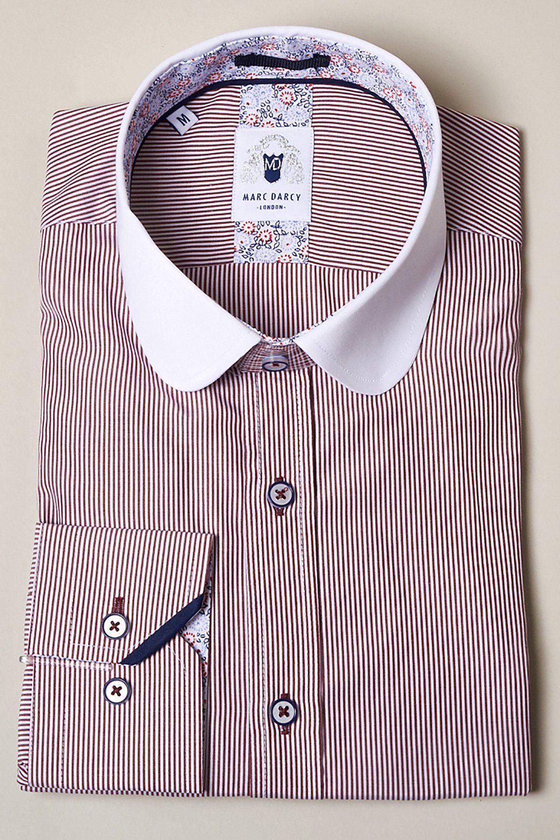 The SHELBY Wine Stripe Penny Collar Shirt by Marc Darcy features long sleeves, thin red and white vertical stripes, a contrast white collar, floral inner collar, and buttoned cuffs. The label reads Marc Darcy.