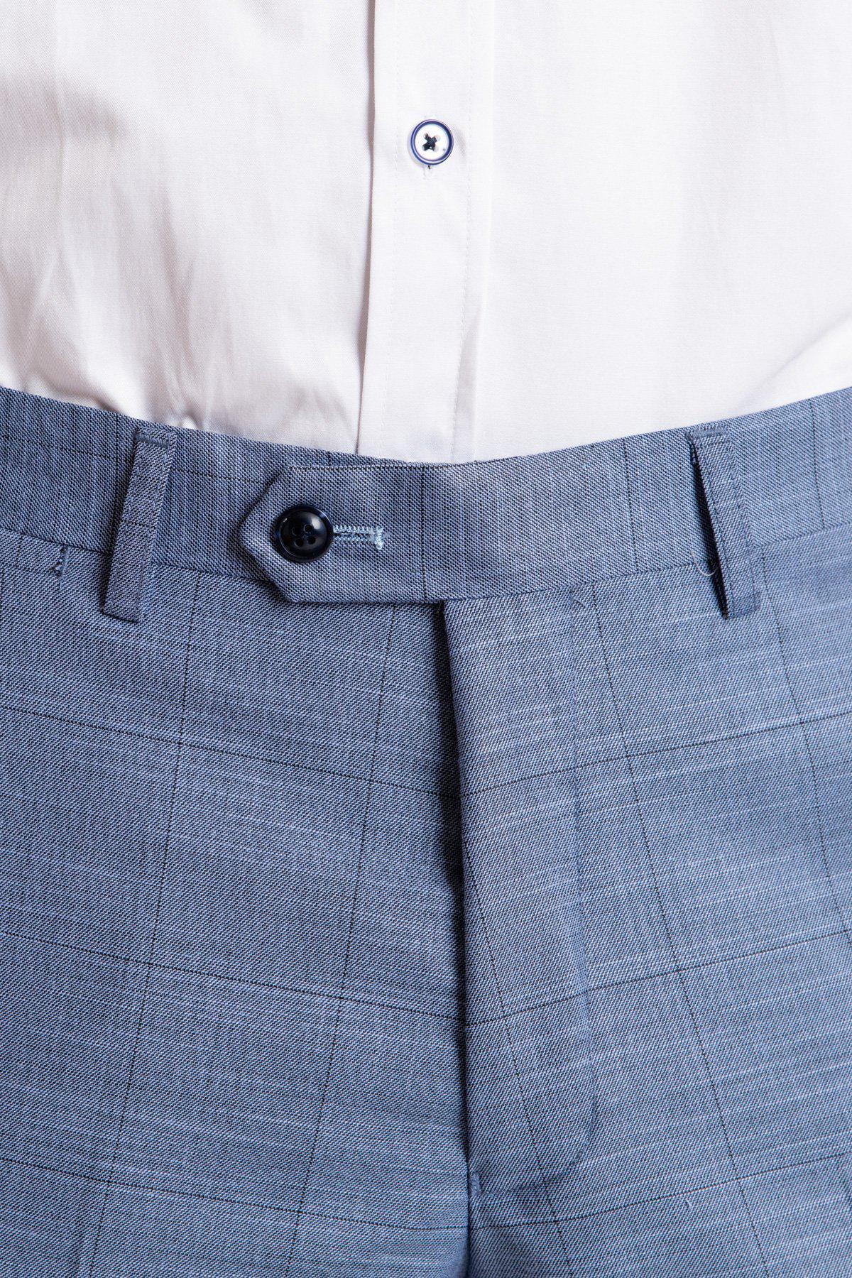 A close-up of a person wearing marcdarcy’s SID - Blue Grey Check Trousers with a black button, paired with a tucked-in white dress shirt.