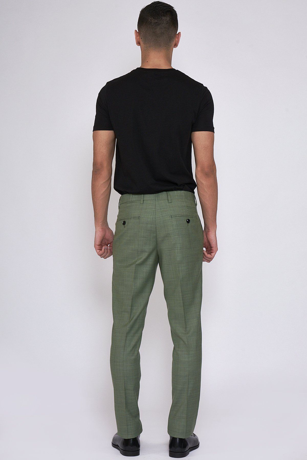 Back view of a man wearing a black t-shirt and marcdarcy SID - Moss Green Check Trousers.