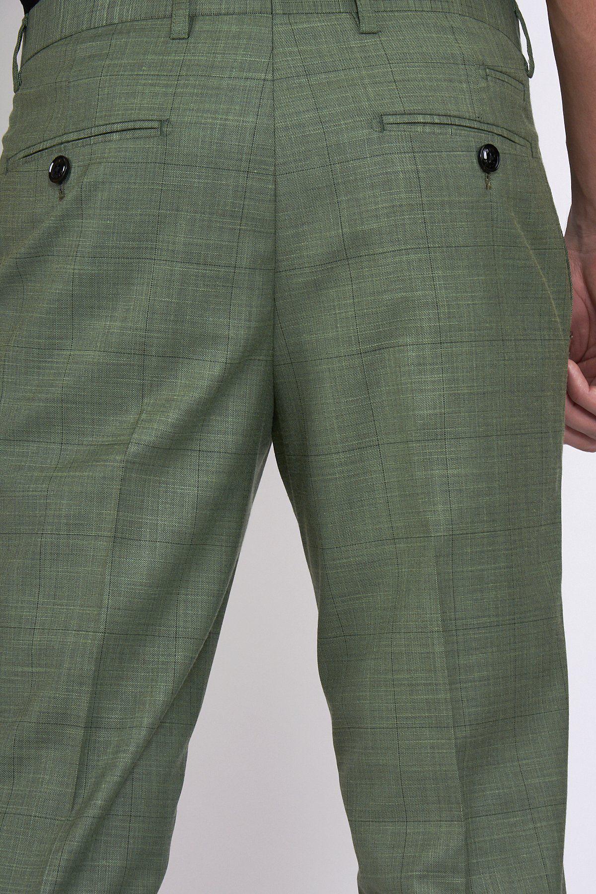 Close-up of the back of a person wearing marcdarcy SID - Moss Green Check Trousers, featuring two back pockets each with a black button; their right hand rests at their side.