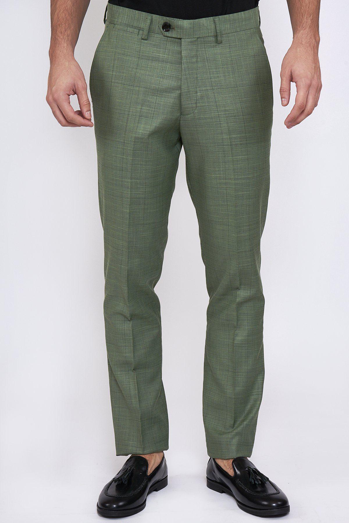 A person, shown from the waist down, wears marcdarcy SID Moss Green Check Trousers with a black belt and black tassel loafers, standing against a plain white background.