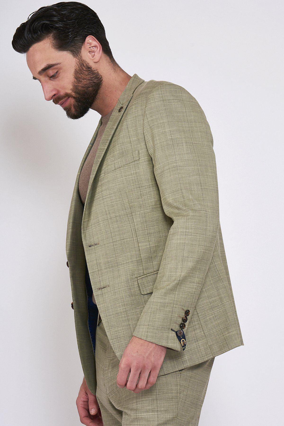 A man with dark hair and a beard wears the marcdarcy SID - Mustard Beige Check Blazer over a beige shirt, standing against a plain white background and looking downwards.