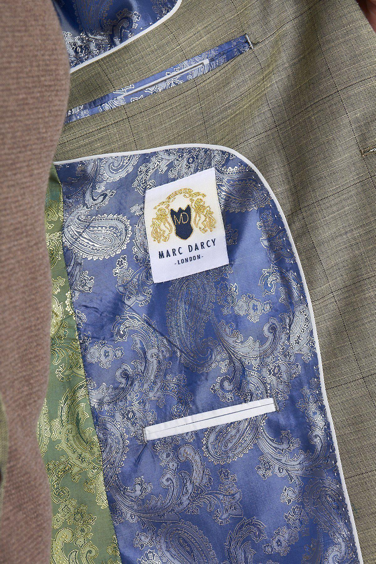 Close-up of the inside of the marcdarcy SID - Mustard Beige Check Blazer, featuring a blue paisley lining, white trim, small inner pocket, and a label with the marcdarcy name and gold crest.