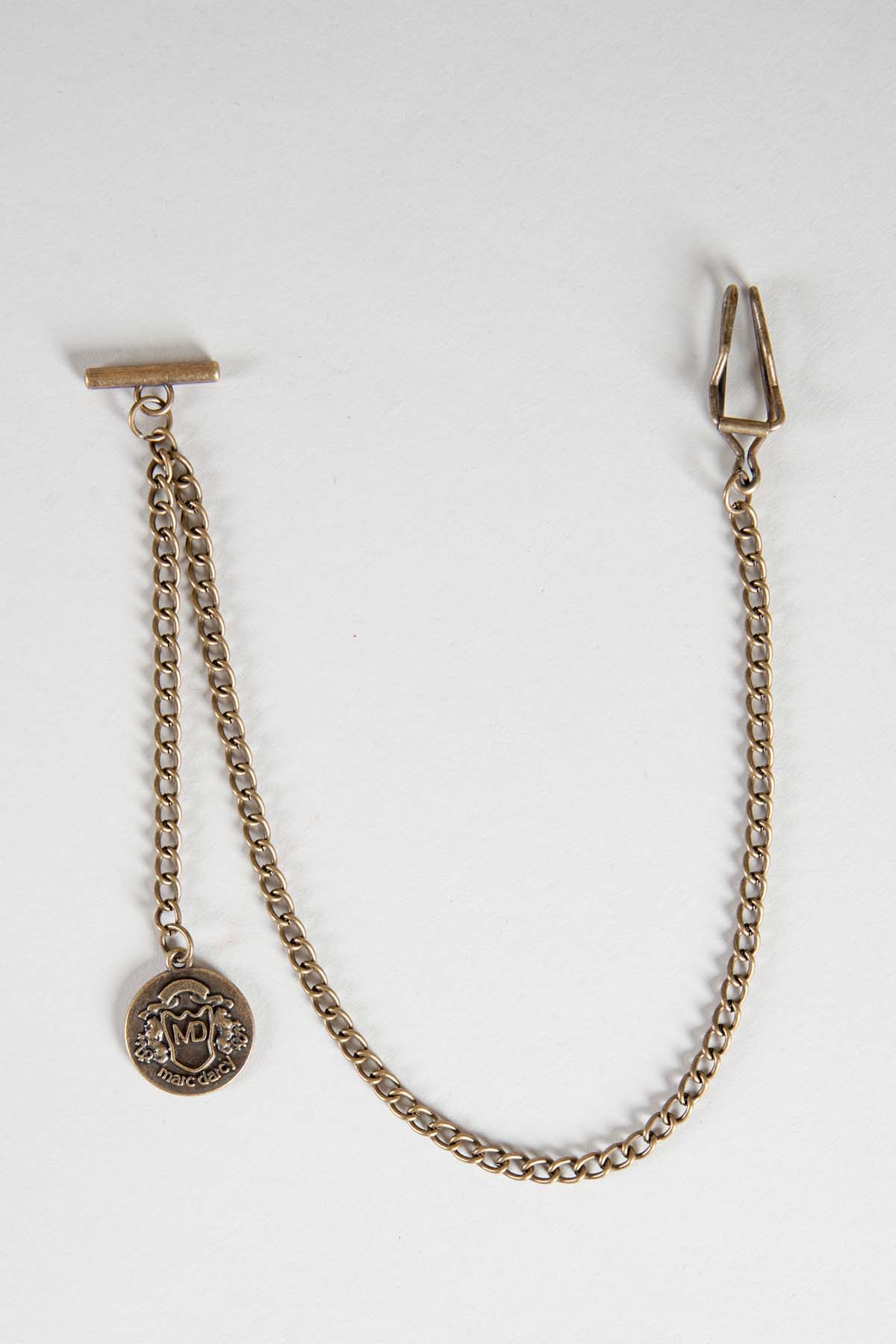 The Marc Darcy Antique Style Gold Plated T-Bar Waistcoat Chain features a clip end and a decorative embossed medallion, and comes with an MD velvet keepsafe pouch. Product shown on a plain white background.
