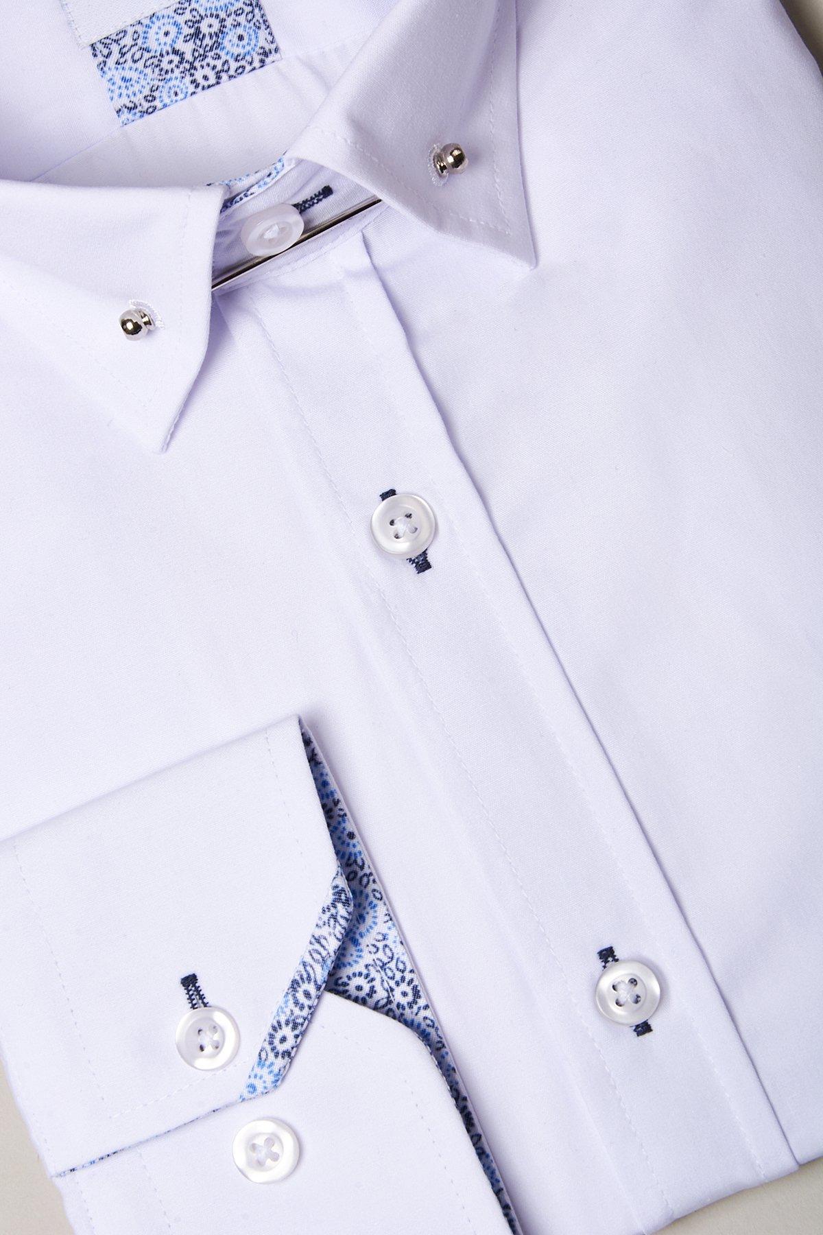 Close-up of the marcdarcy SUTTON white shirt with a collar bar, blue patterned trim on the collar and cuffs, and white buttons—a stylish choice for evening wear.
