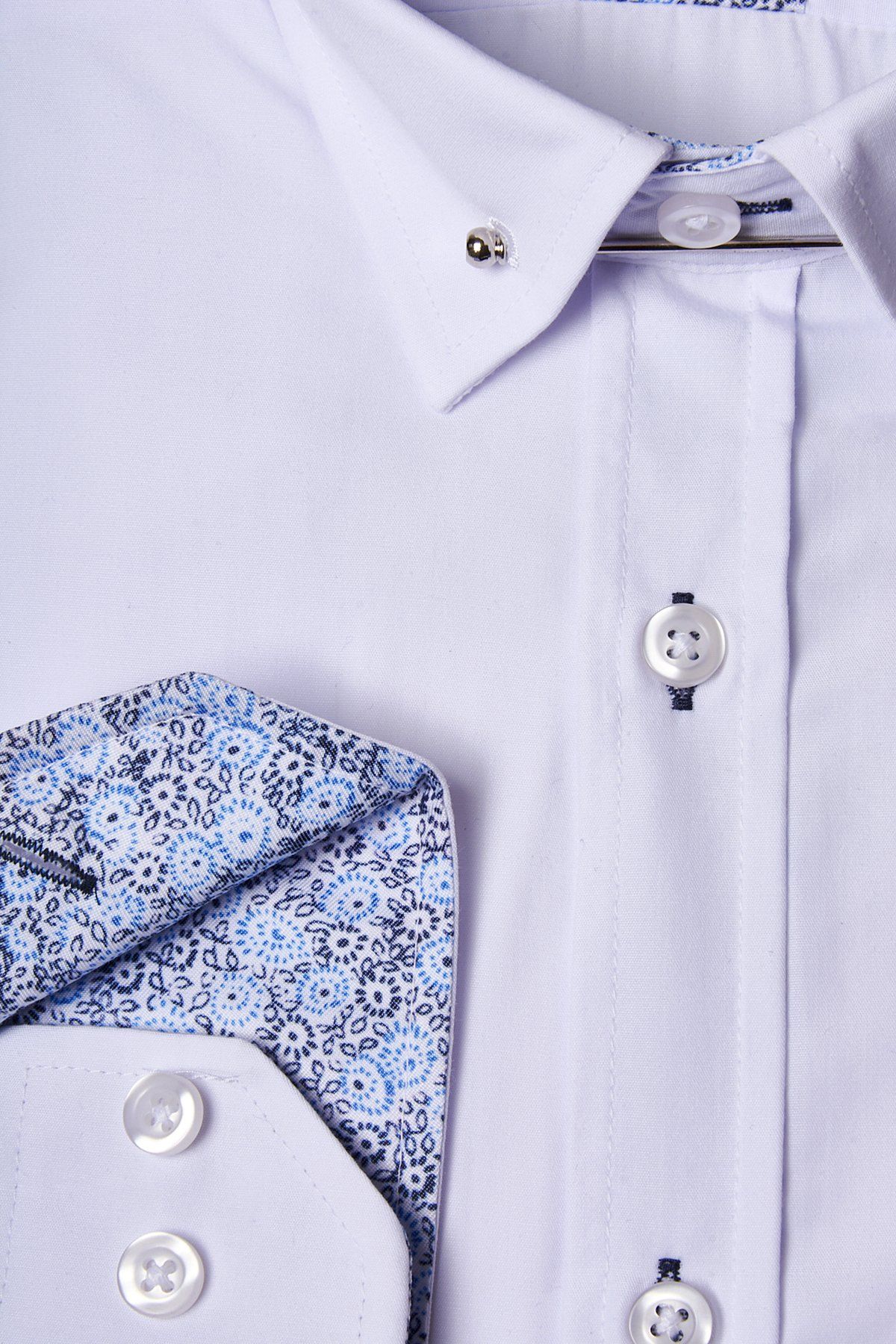 Close-up of the marcdarcy SUTTON white shirt with collar bar. Crafted from a cotton-blend, it features blue and black floral-patterned collar and pocket linings—impeccably pressed and ideal for formal occasions.