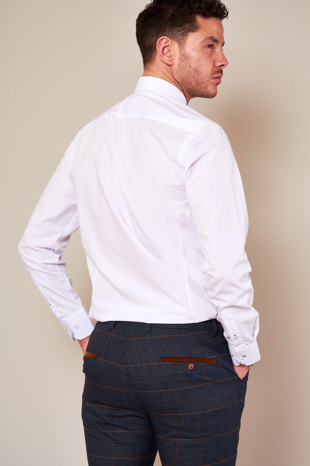A man with short, curly hair stands with his back to the camera, hands in pockets, wearing the marcdarcy SUTTON white shirt with collar bar and gray checkered trousers with brown pocket accents—ideal for formal occasions.