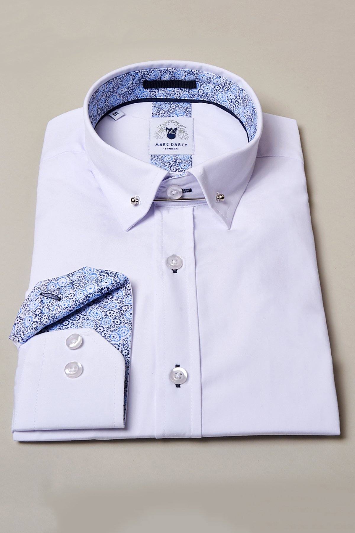 A SUTTON white shirt with a collar bar by marcdarcy, featuring a patterned blue and white inner collar and cuffs, cotton-blend fabric, white buttons, and the brand label inside the collar, displayed on a beige background.