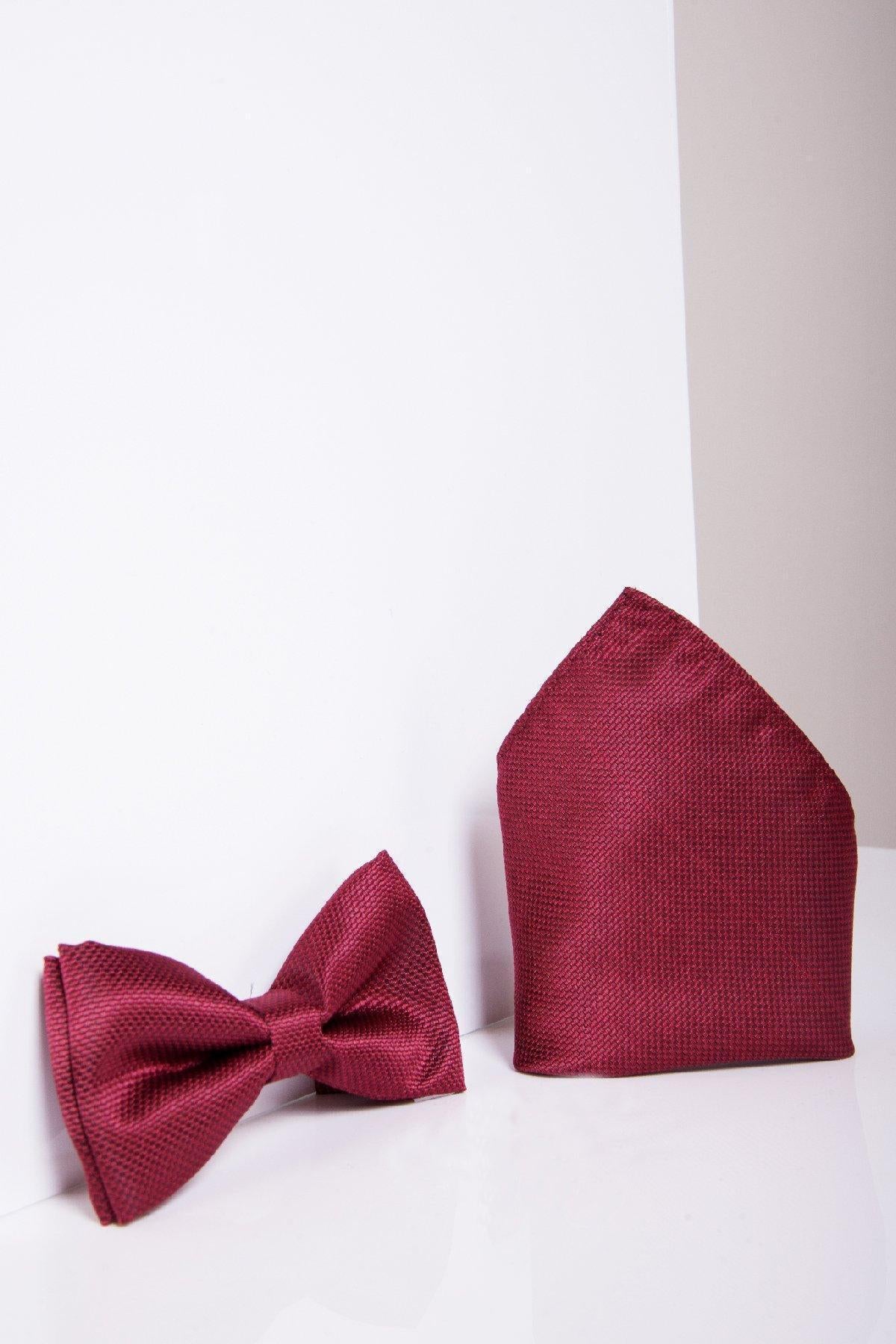 The TOBY Birdseye Print Bow Tie and Pocket Square Set in Wine by Accessory rests on a white surface, perfect as a tuxedo accessory with its rich wine hue and elegant design.