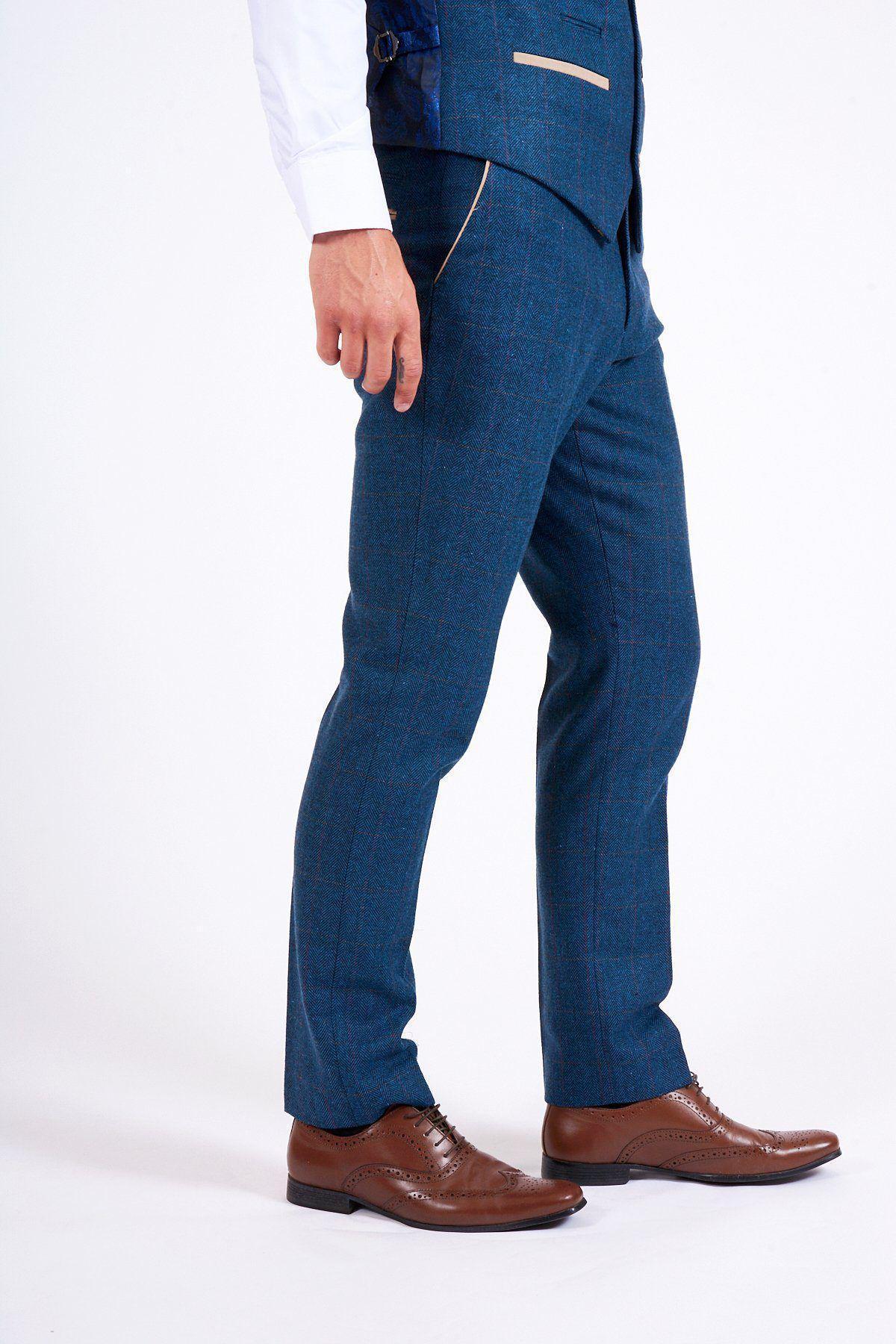 A person wearing the marcdarcy DION Blue Tweed Suit As Worn By Sam Johnstone with a white shirt and brown leather dress shoes is shown from the shoulders down against a plain white background.