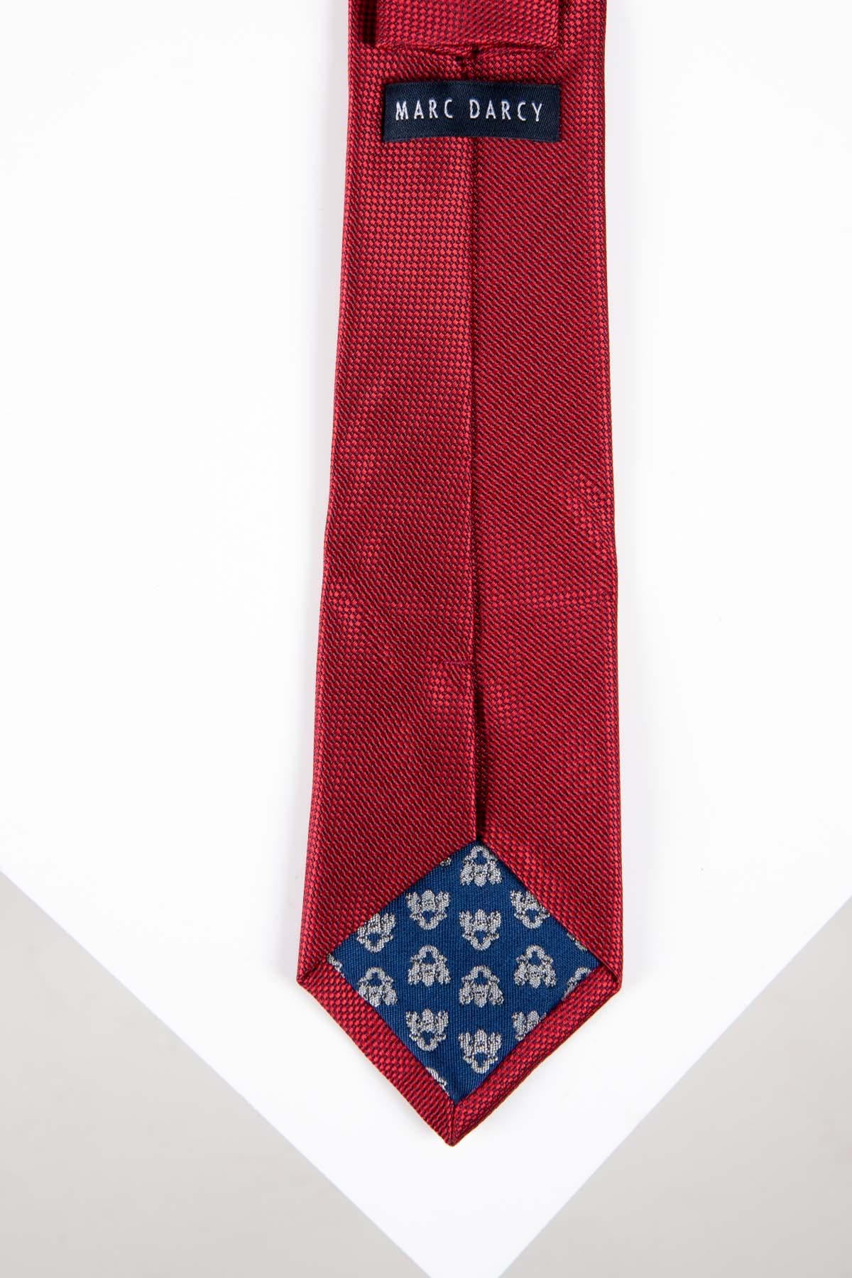 The TOBY Birdseye Tie and Pocket Square Set in Wine by Accessory features a textured red tie with a subtle birdseye pattern and blue diamond-shaped insert with silver floral detail—a standout addition to any set.