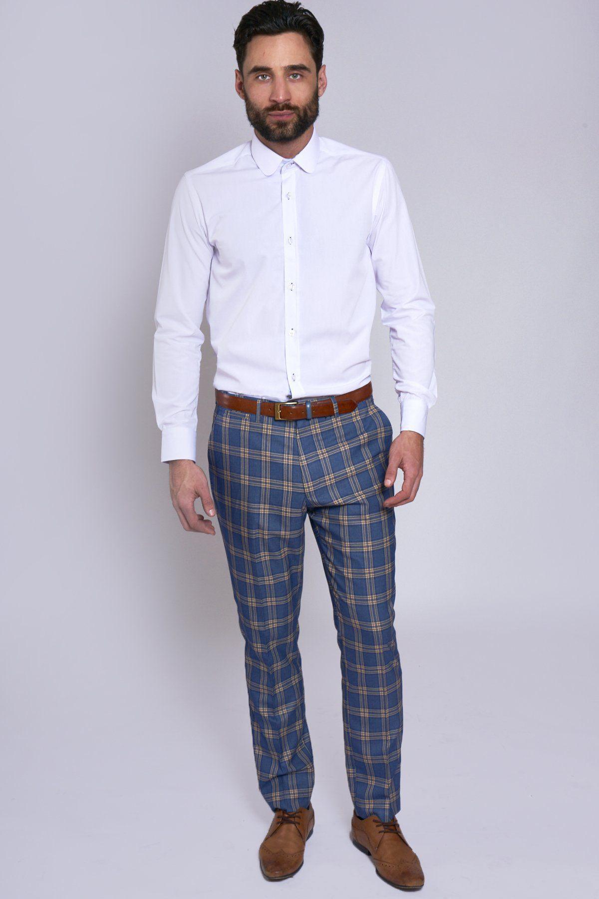 A man with dark hair and a beard stands against a plain light background wearing the marcdarcy TONY Blue Yellow Check Suit with a single breasted waistcoat, white dress shirt, brown belt, and brown dress shoes, looking directly at the camera.
