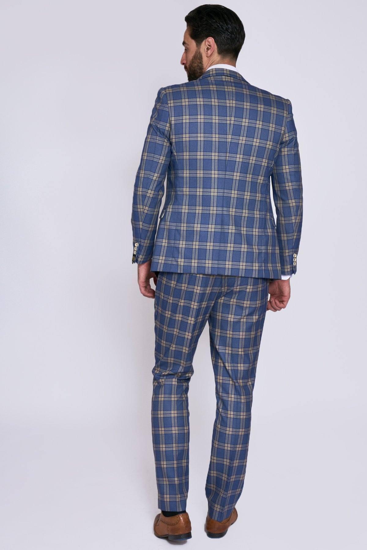 A man faces away, wearing the marcdarcy TONY Blue Yellow Check Suit with Single Breasted Waistcoat and brown dress shoes, set against a plain light background.
